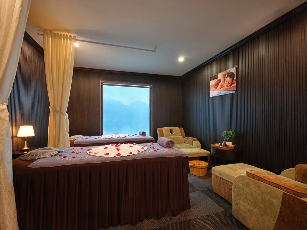 Relaxing spa room with cozy bed and scenic window view in Lan Ha Bay.