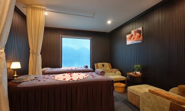 Relaxing spa room with cozy bed and scenic window view in Lan Ha Bay.