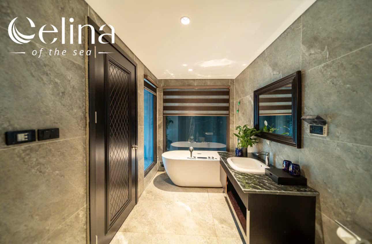 Luxurious bathroom with a freestanding white tub, double sink vanity, marble countertop, and logo 'Celina of the sea' in the upper left corner.