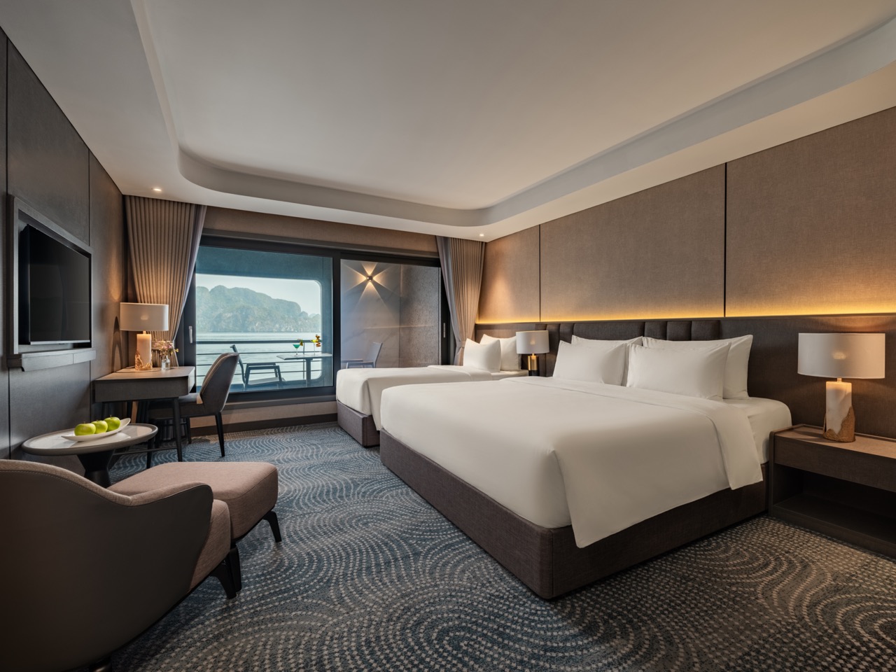 Luxurious hotel room with two large beds, soft lighting, and a balcony overlooking the sea or mountains.