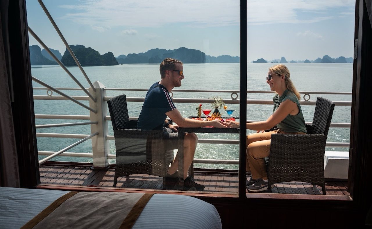 bai-tu-long-cruise-private-balcony-couple-cocktails-sea-view-viettrendtour Clink glasses and watch the karsts drift by—slow travel tastes better together.