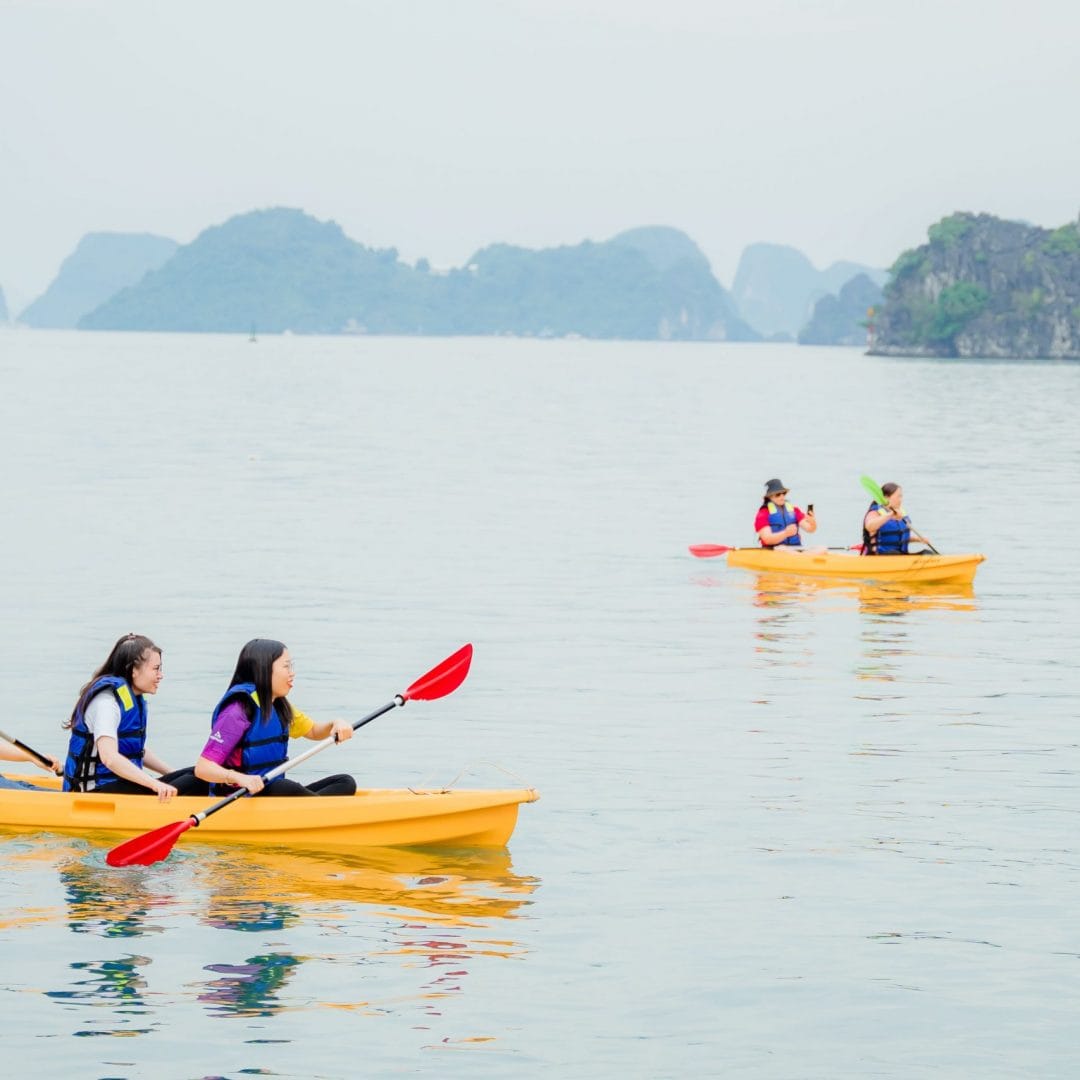 lan-ha-bay-cruise-group-kayaking-viettrendtour Friends paddle side by side, swapping smiles and photos as islets rise all around.