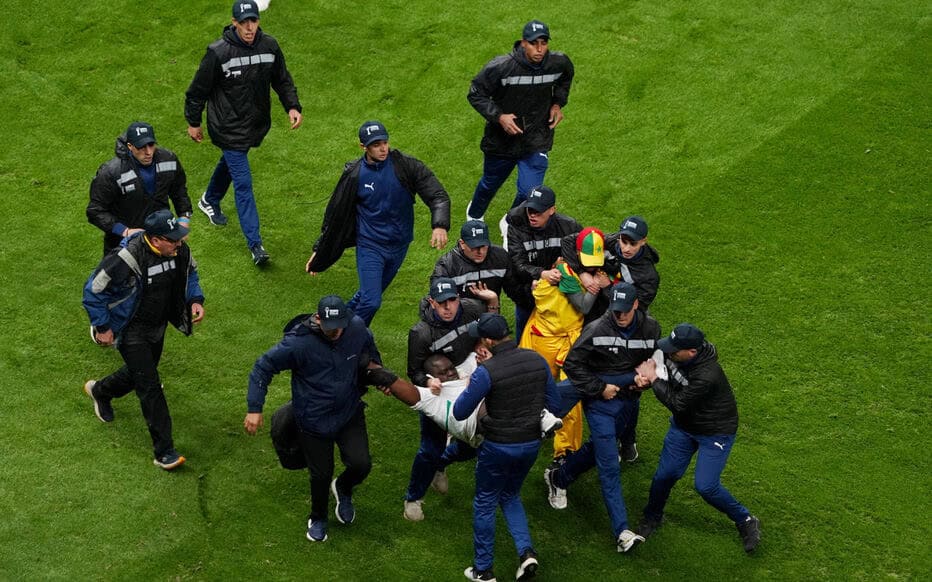 FILE PHOTO: Soccer Football - CAF Africa Cup of Nations - Morocco 2025 - Final - Senegal v Morocco - Prince Moulay Abdellah Stadium, Rabat, Morocco - January 18, 2026
Security staff tackle Senegal fans who invaded the pitch after Morocco were awarded a penalty following a VAR review REUTERS/Stringer/File Photo
