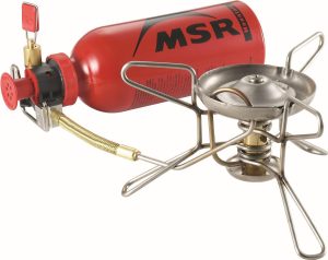 A camping stove with a red fuel bottle, featuring a sturdy metal base and a burner area for cooking in outdoor settings.