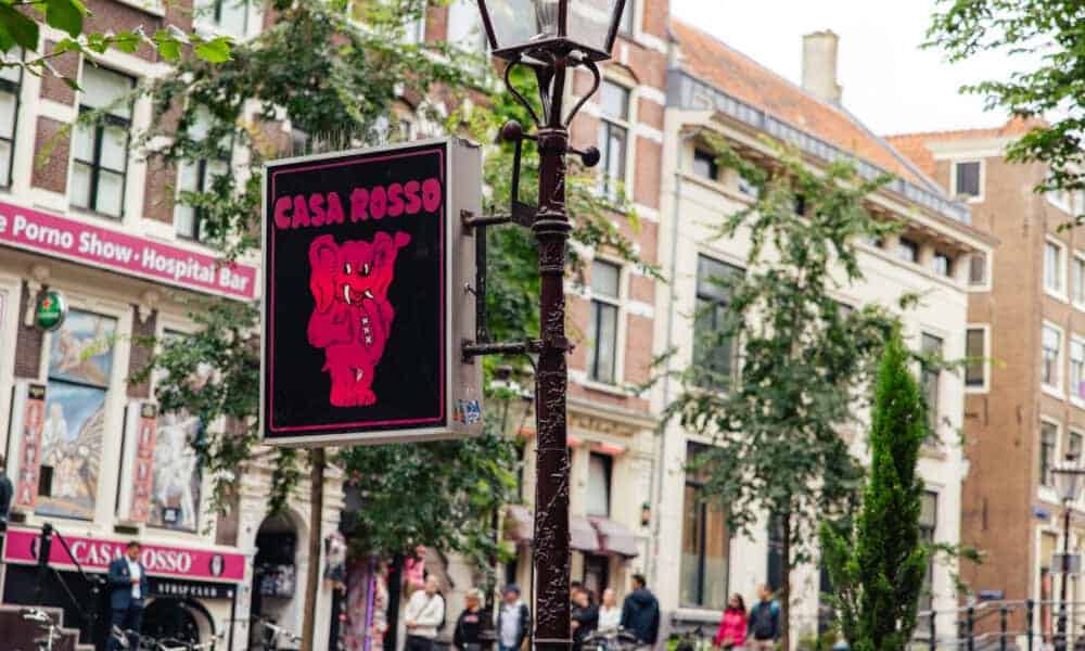 A sign for Casa Rosso on a street in Amsterdam. The sign features a red logo.