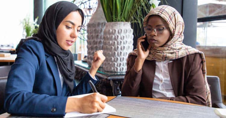 two woman wearing a hijab at the office