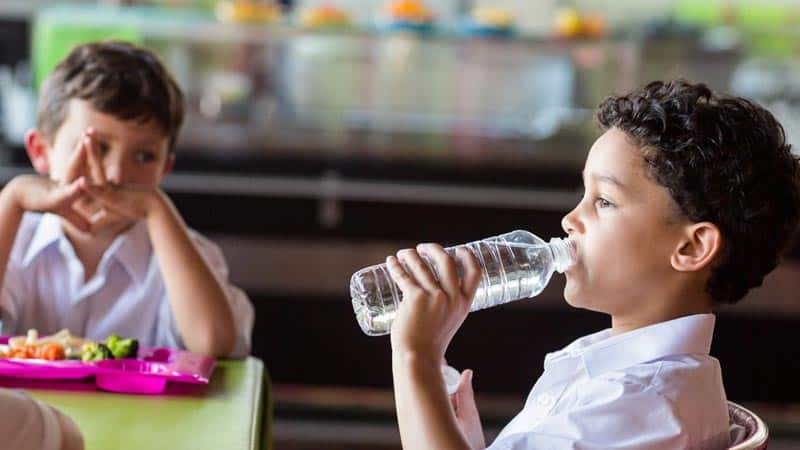 French student drinking water at lunch because milk is not an option