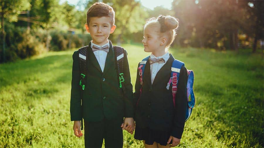 cute French girl in a boys suit holding hands with boy in suit