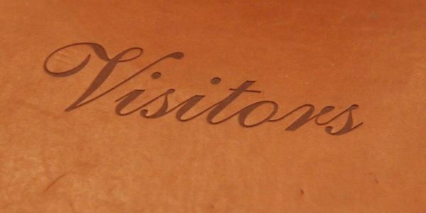 A brown leather book with the word visitors written on it.