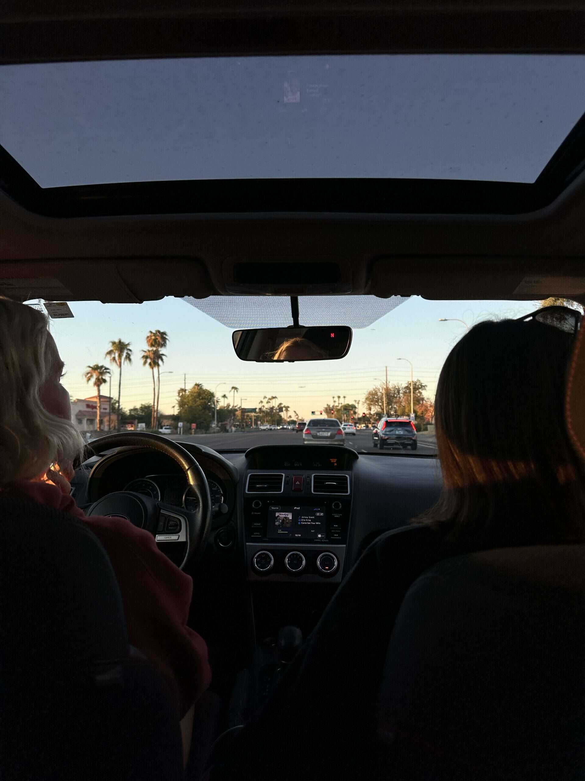 Two women in a car and driving.