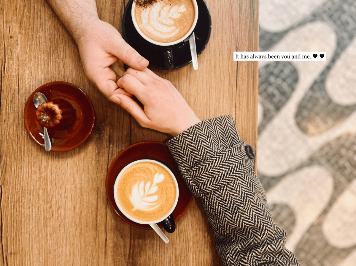 A man and a woman holding hands on a coffee date.
