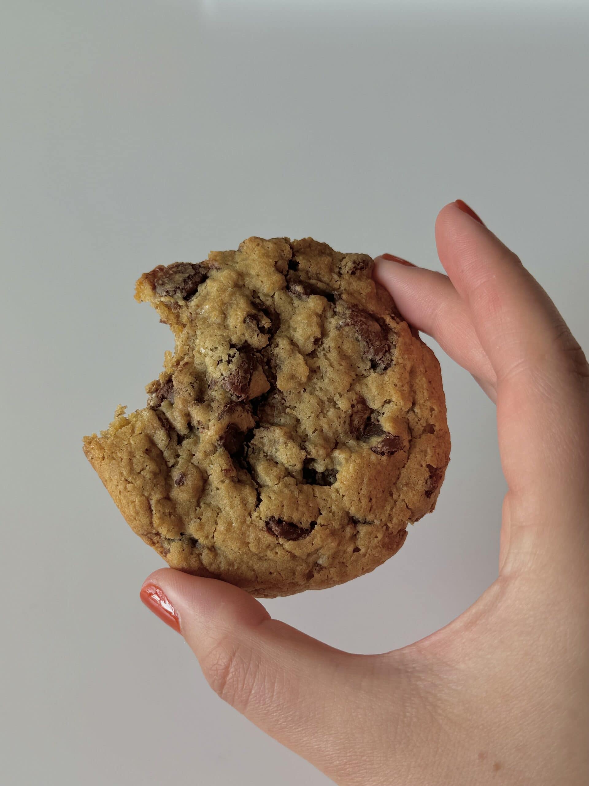 Hand holding a cookie showing that you can use an apple divider to cut up cookie dough.