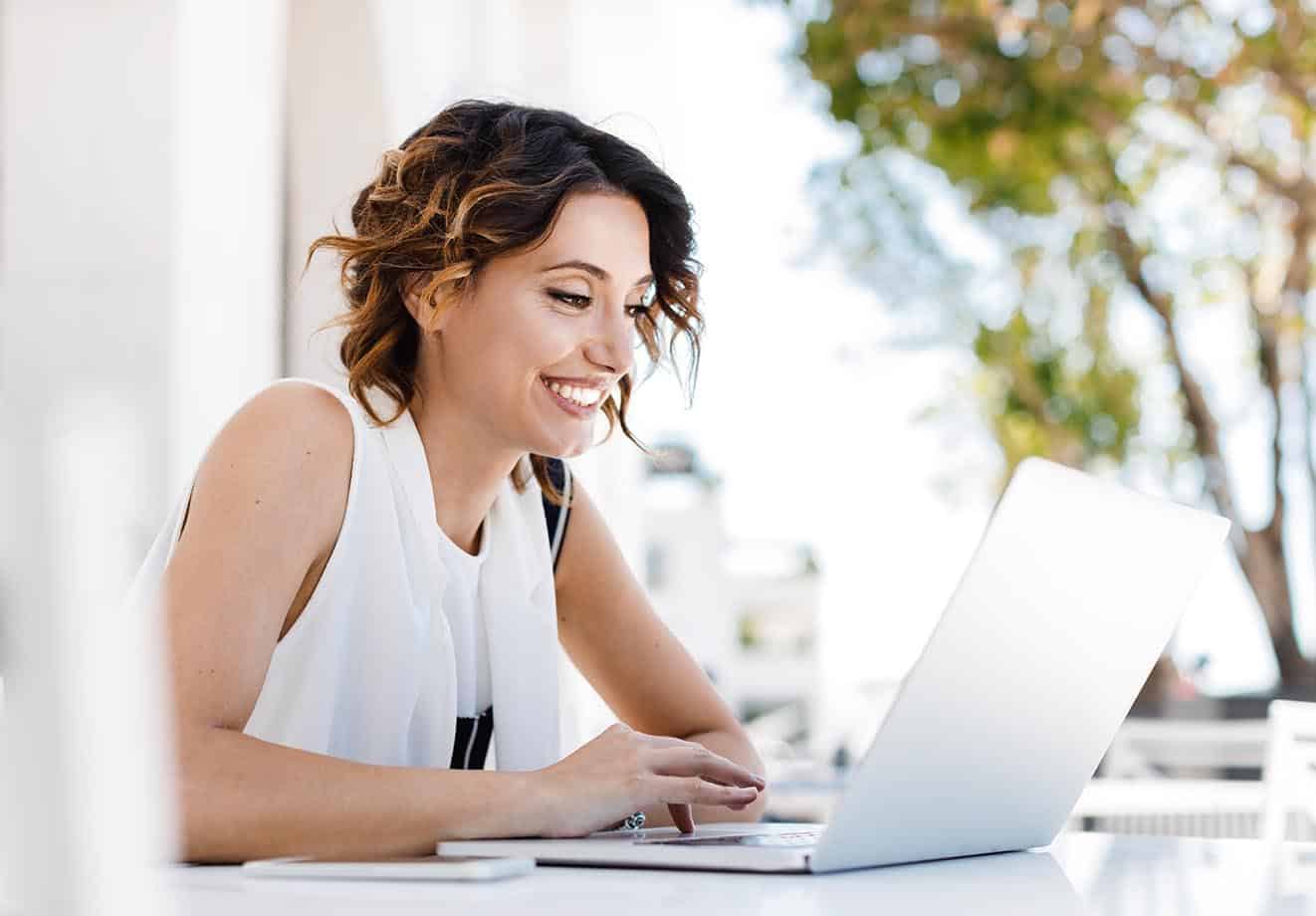 A person uses a laptop at a desk to measure return on investment.