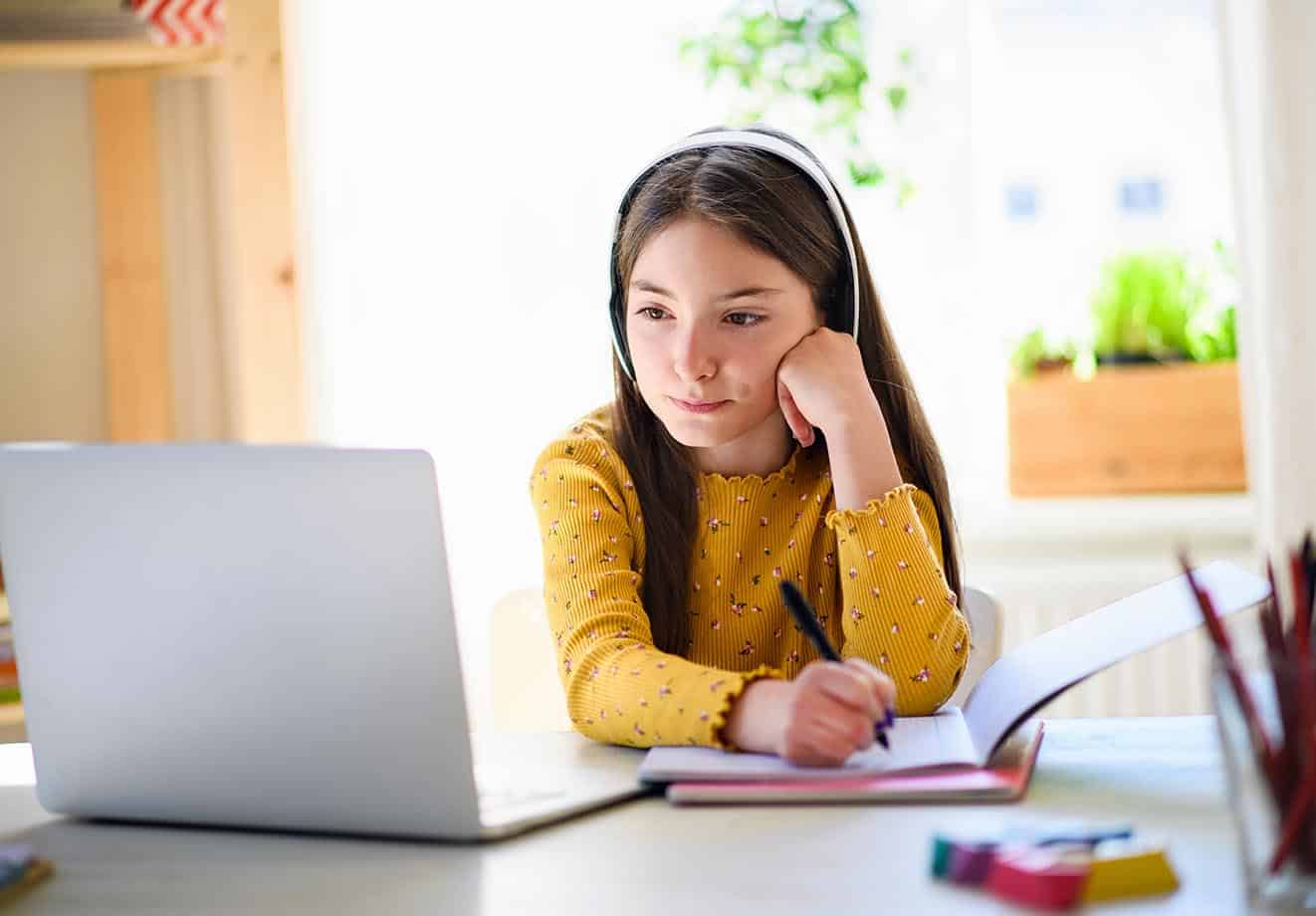 a young girl learns from home on her laptop which shows how much education has changed over the last 100 years and why our ceo john baker is blogging about it