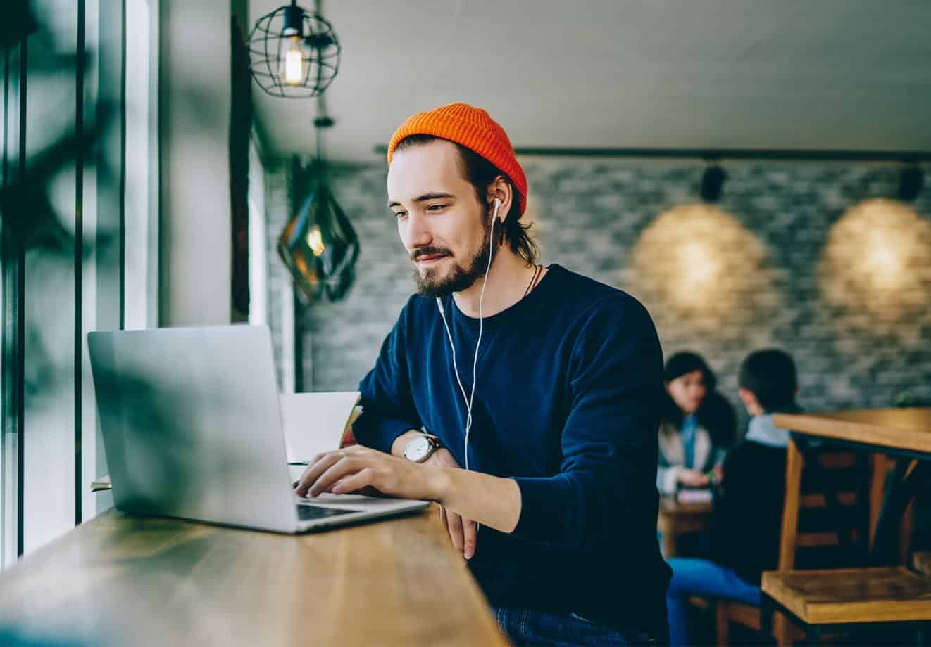 Young man sitting in a coffee shop and working on his laptop