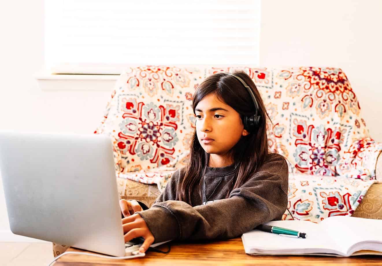 teenage-girl-with-headphones-watching-the-lapyop-screen