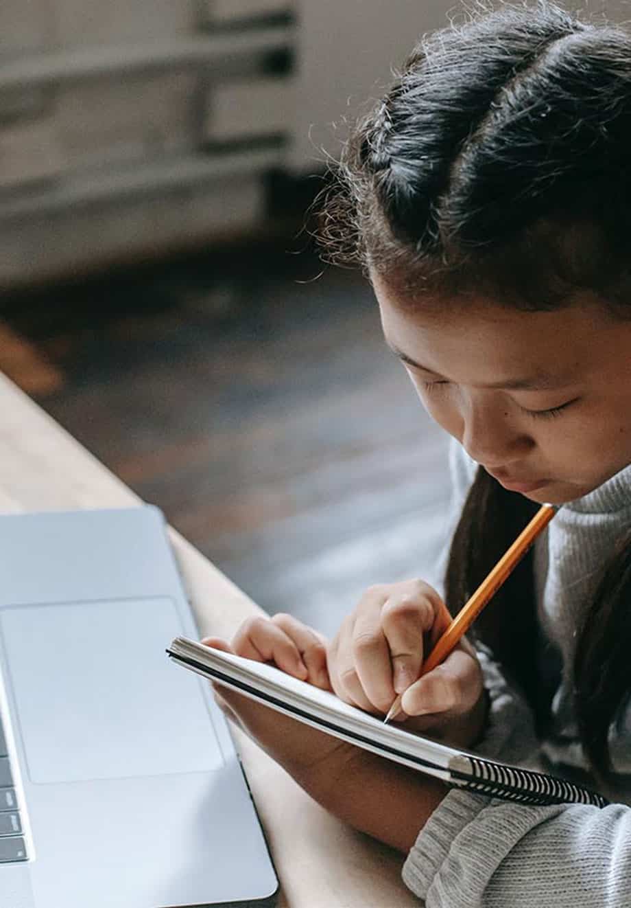 young girl writing on notebook