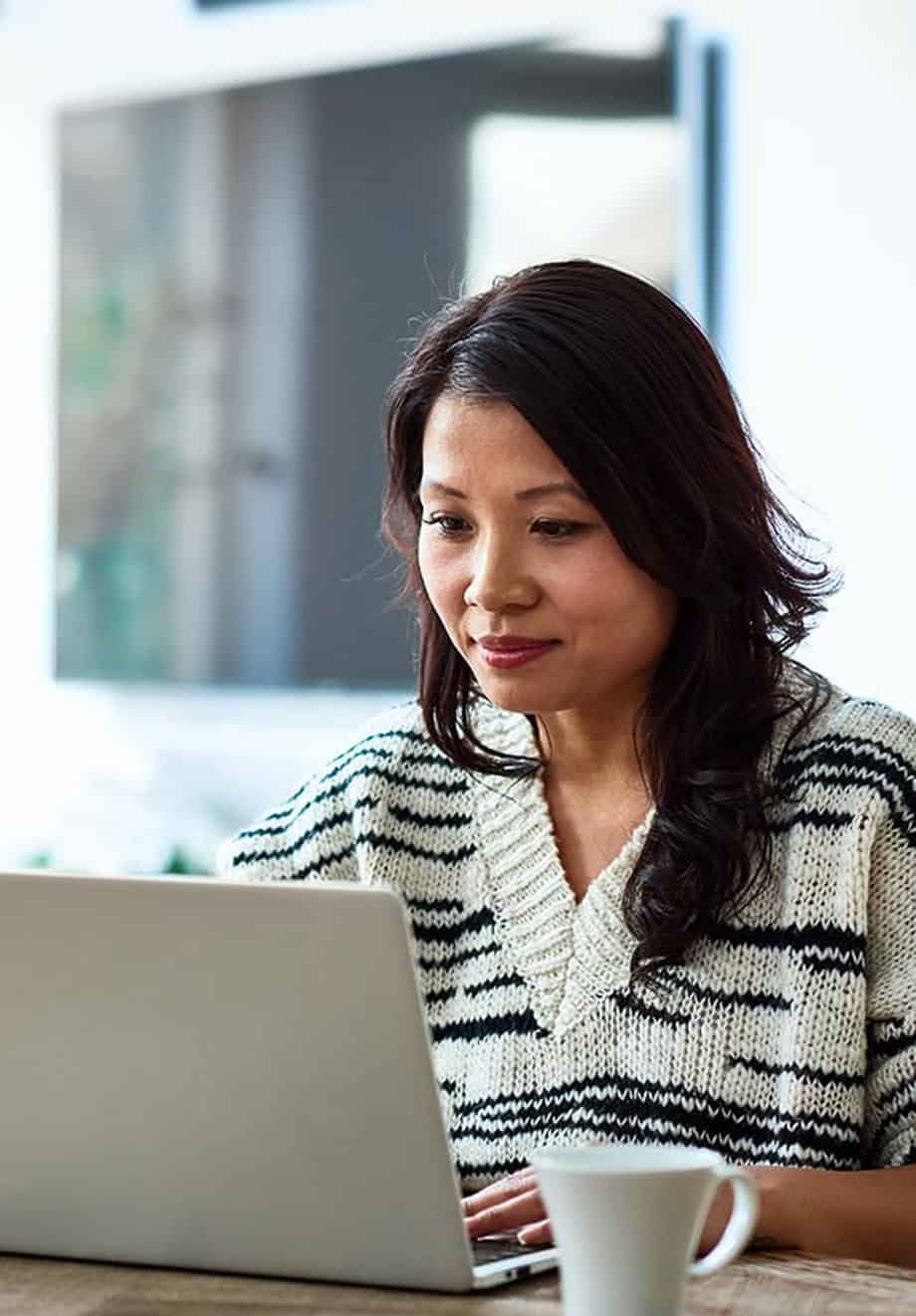 female employee sitting at desk with laptop
