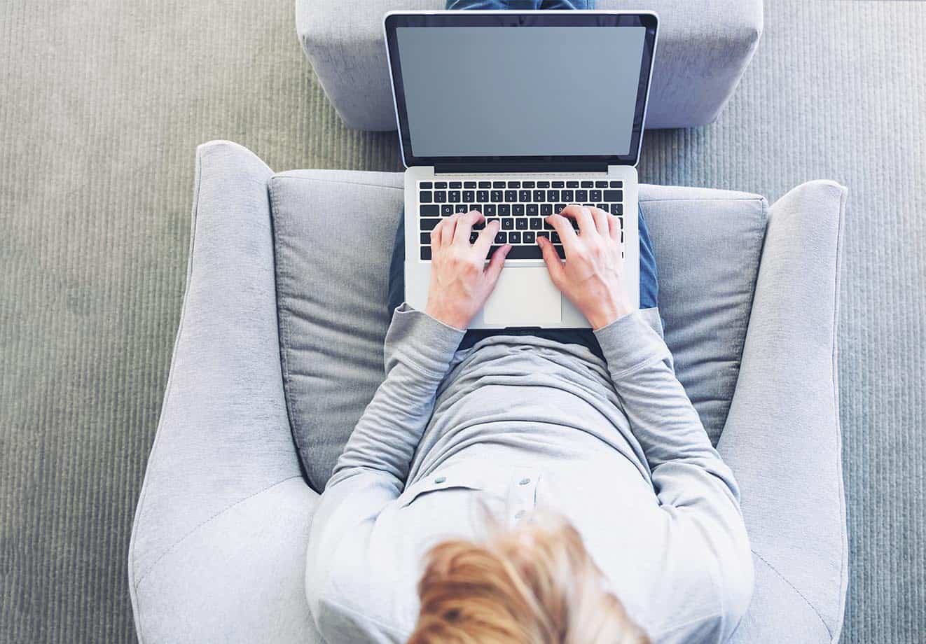 An aerial view of someone using a laptop in a comfortable chair