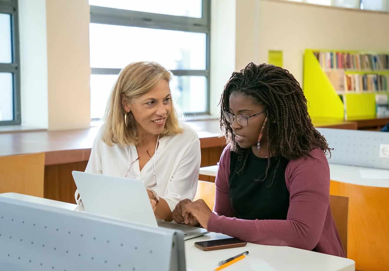 teacher-helping-young-adult-in-computer-lab