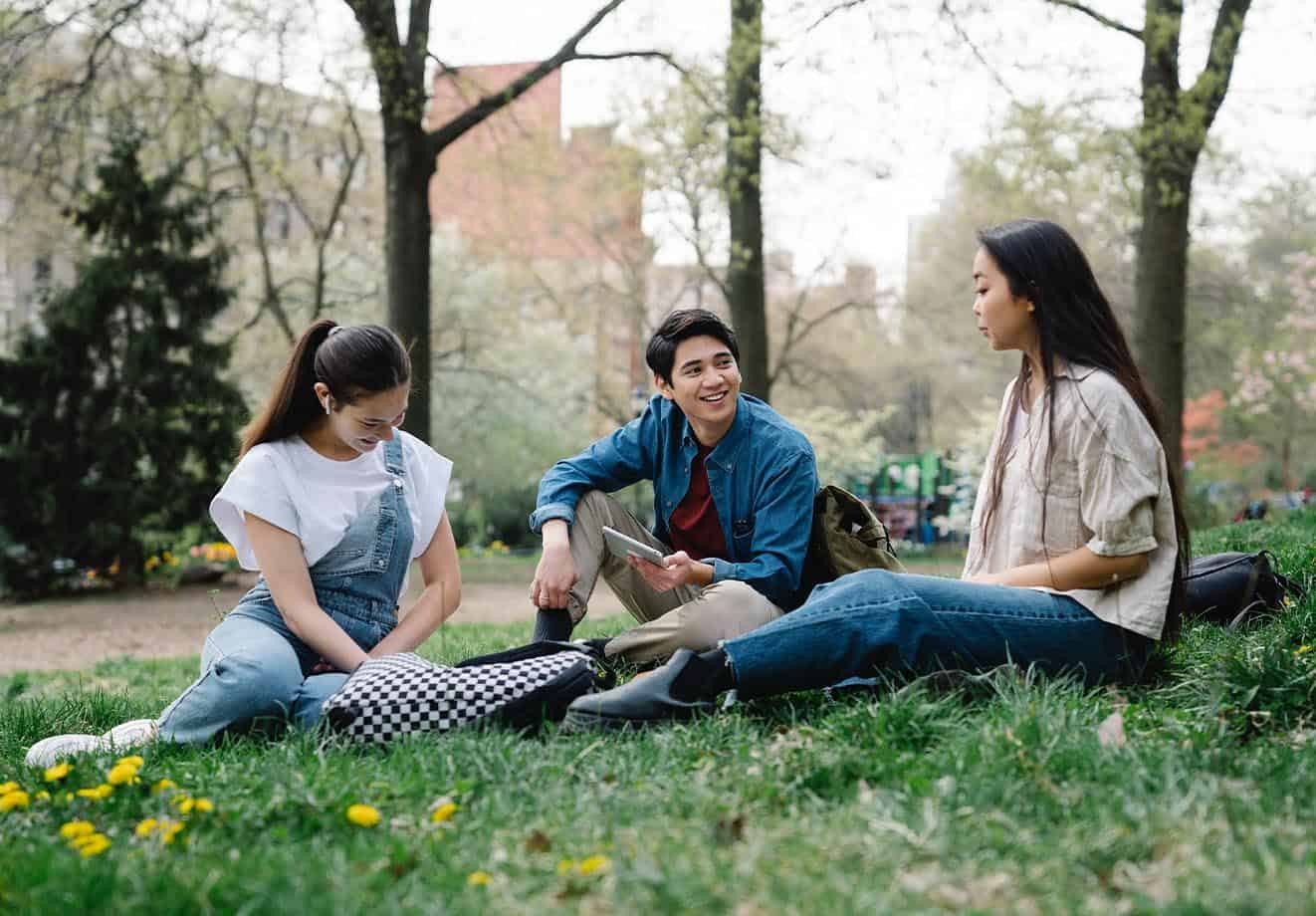 Students sitting in the grass on campus