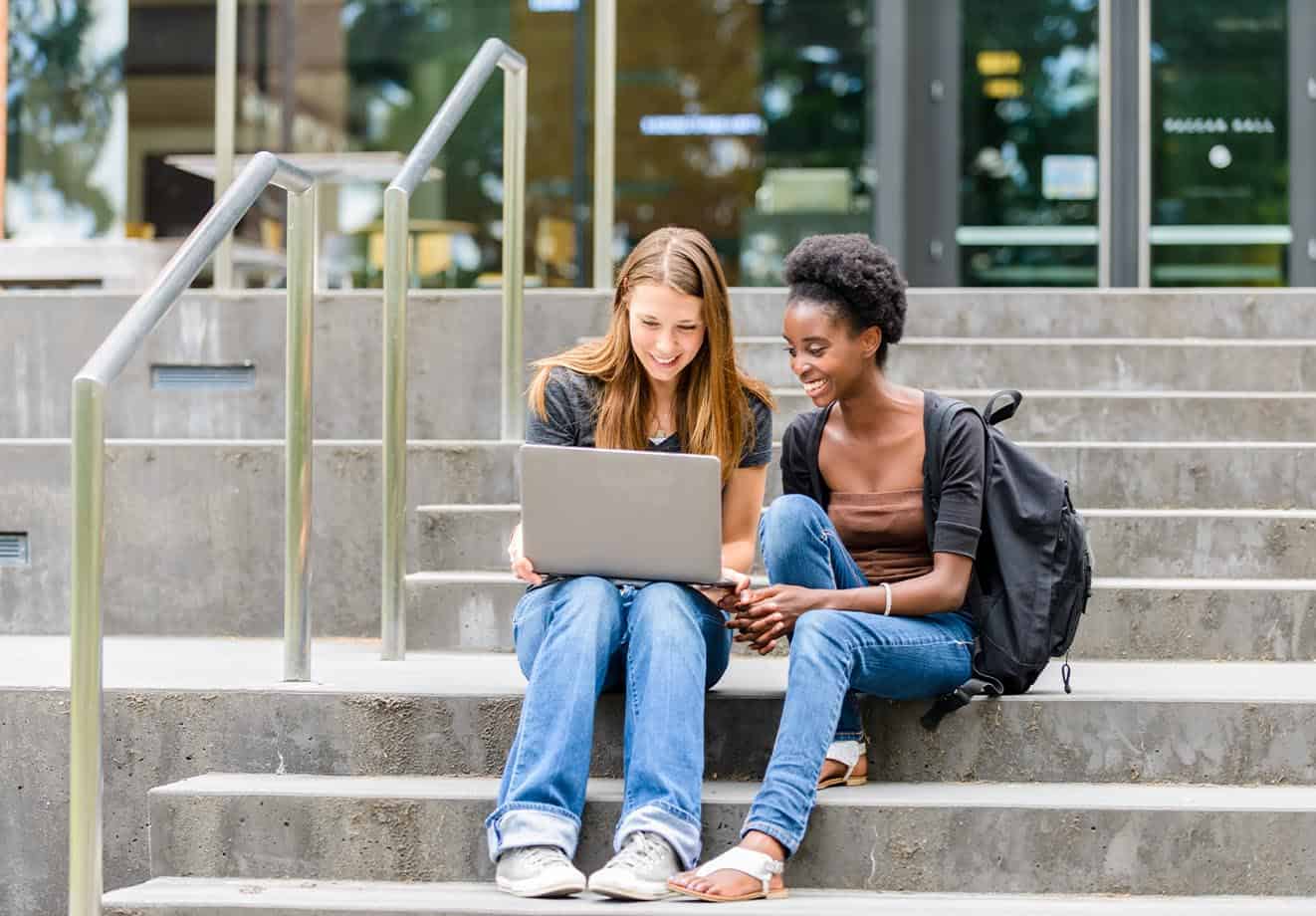 University-students-sitting-on-stairs-with-laptop