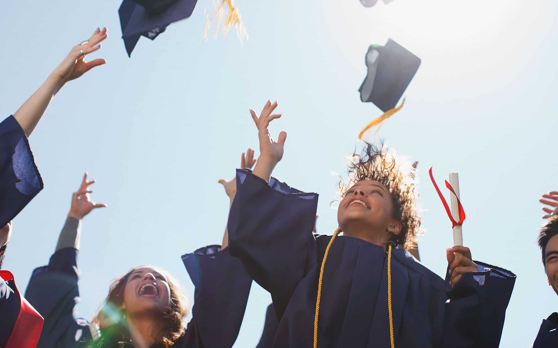 Students throwing their graduation hats in the air