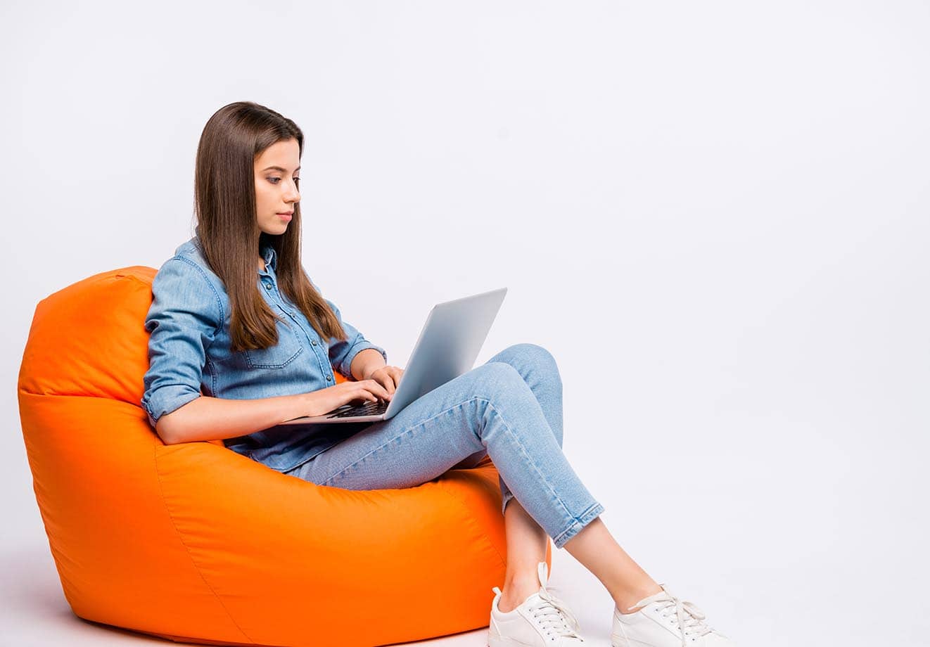 Girl-sitting-on-a-couch-working-on-a-laptop