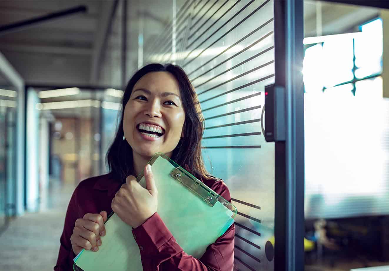 woman smiling at the camera with her clipboard who tells us her story about why she loves blended learning