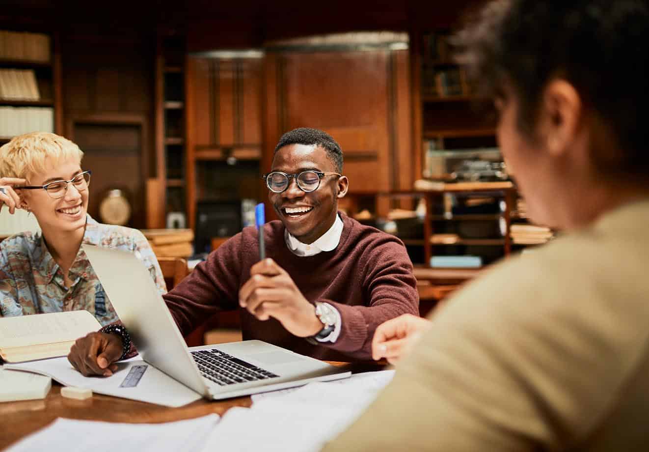 group of college students working around a table in the library