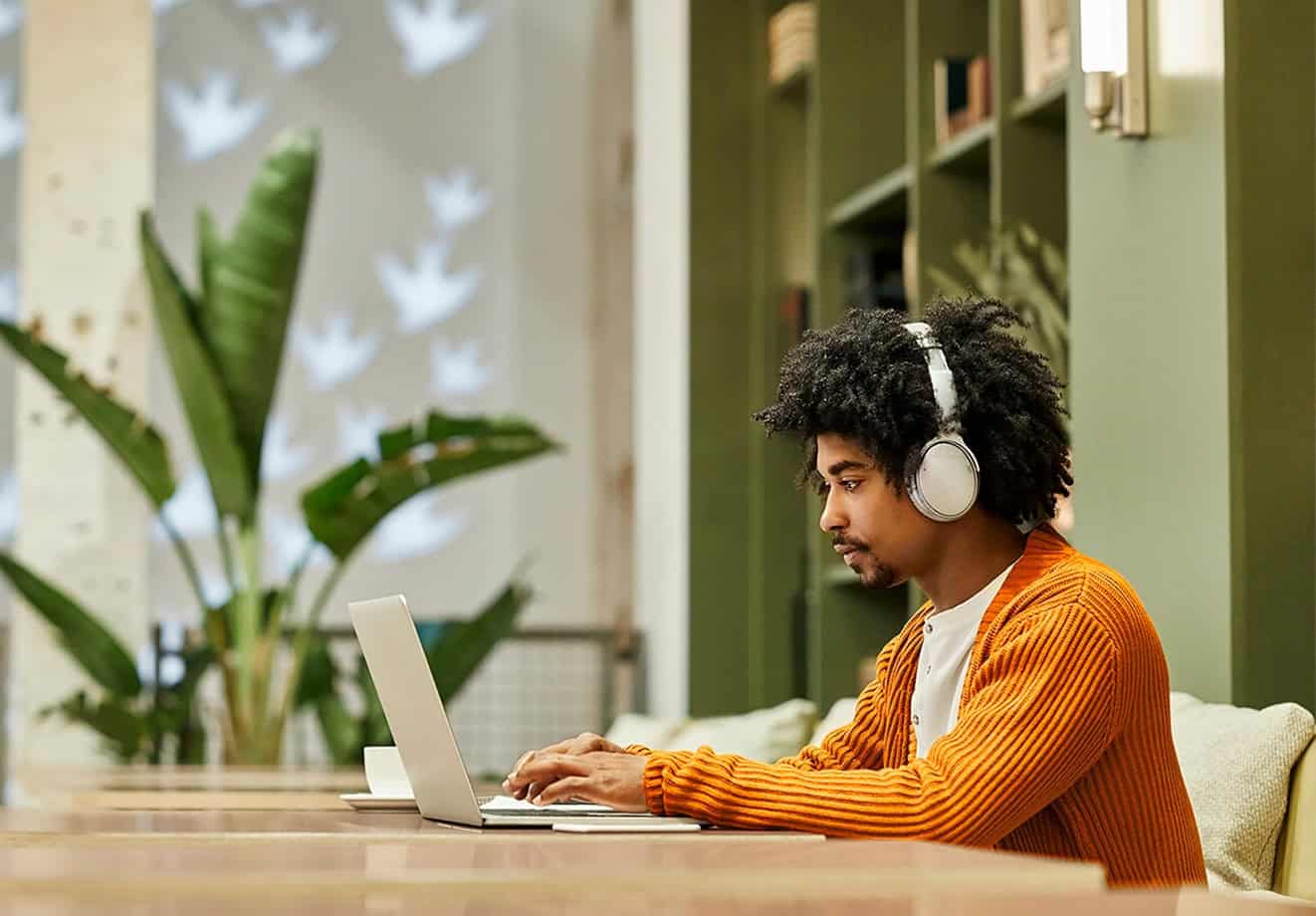 Student working on laptop with headphones on