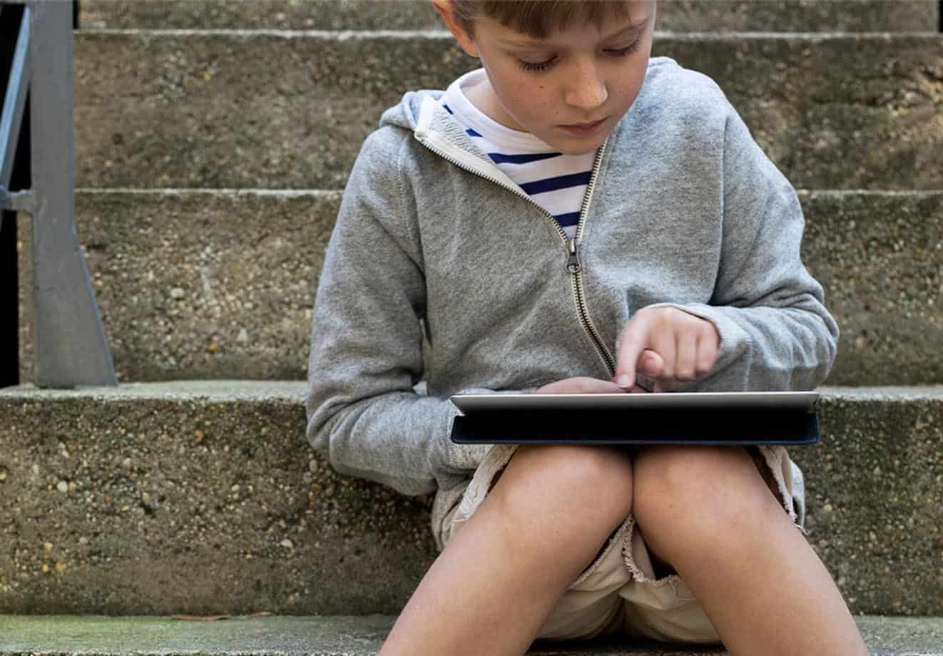 Boy sitting on stairs on tablet