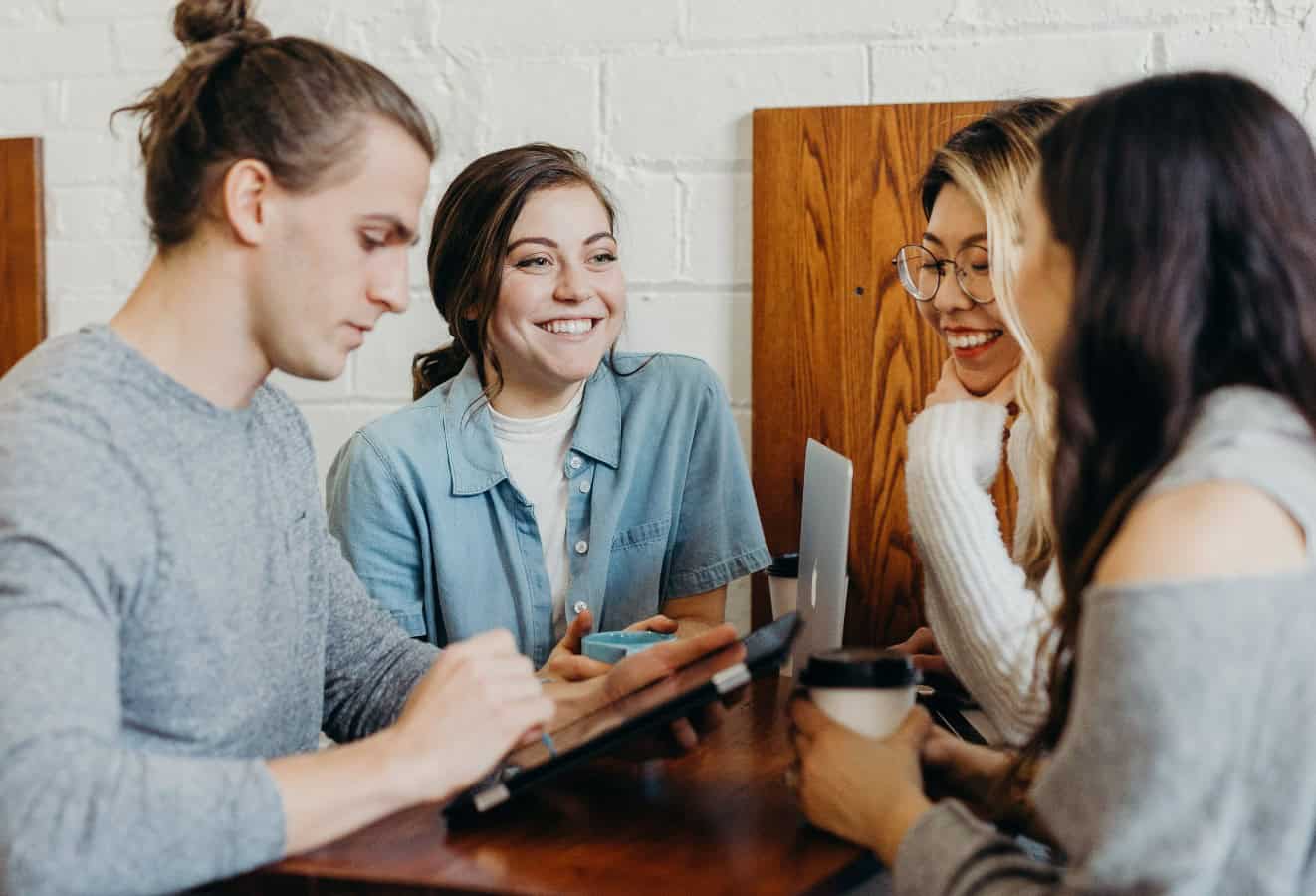 Group of college students studying around a library table