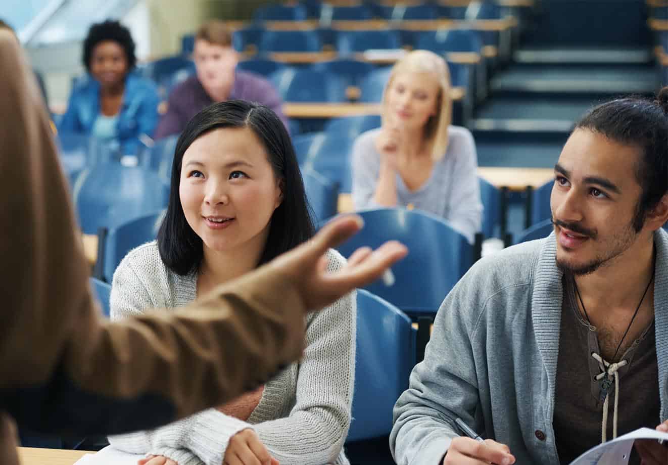 Students sitting in a lecture hall listening to a professor