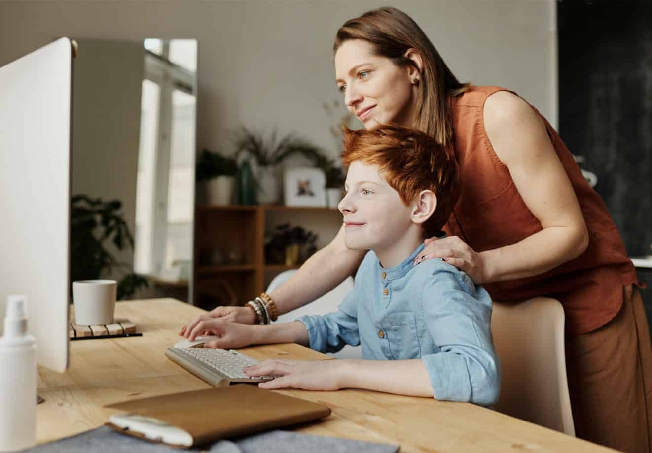 Parent helping child on computer