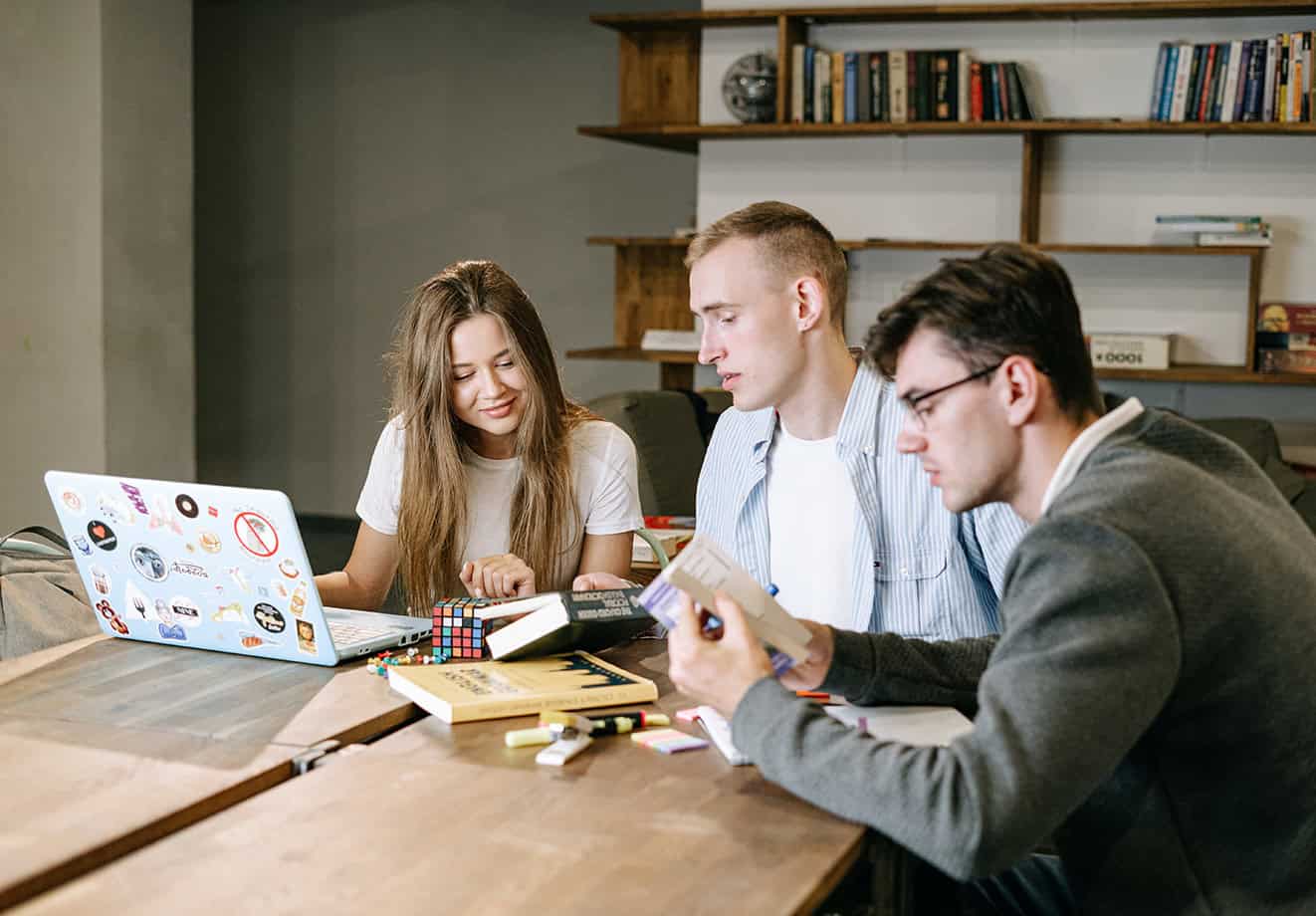three employees talking around table