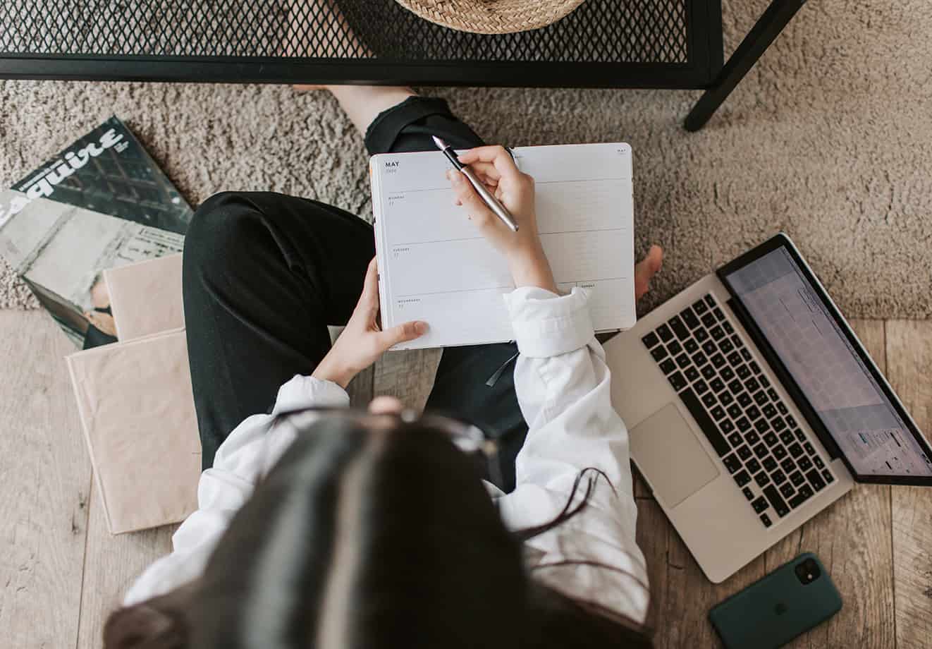 person writing in daily planner