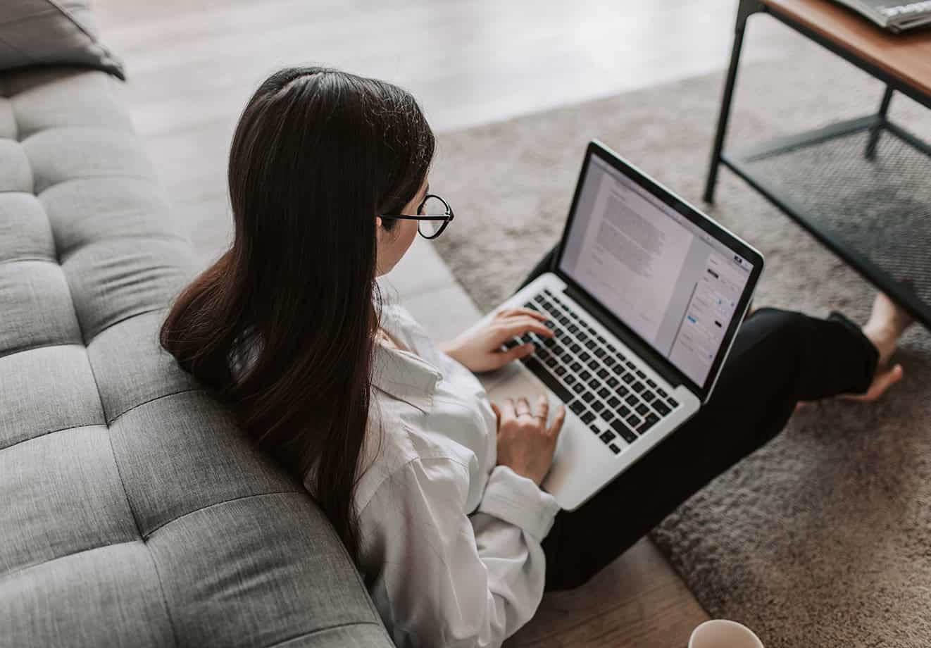 girl sitting on ground working on laptop