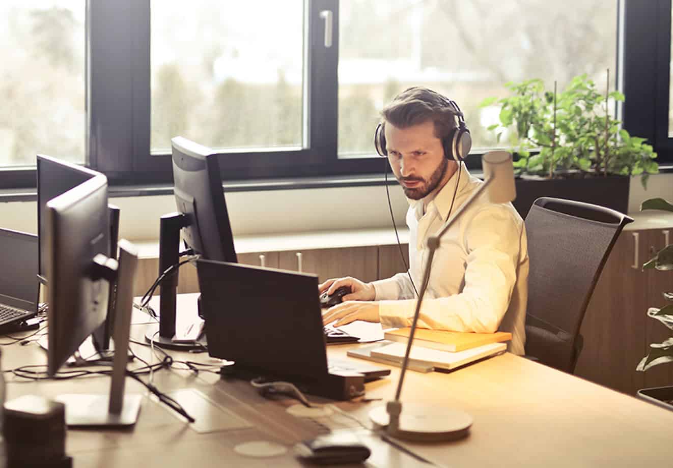 man sitting at desk on computer