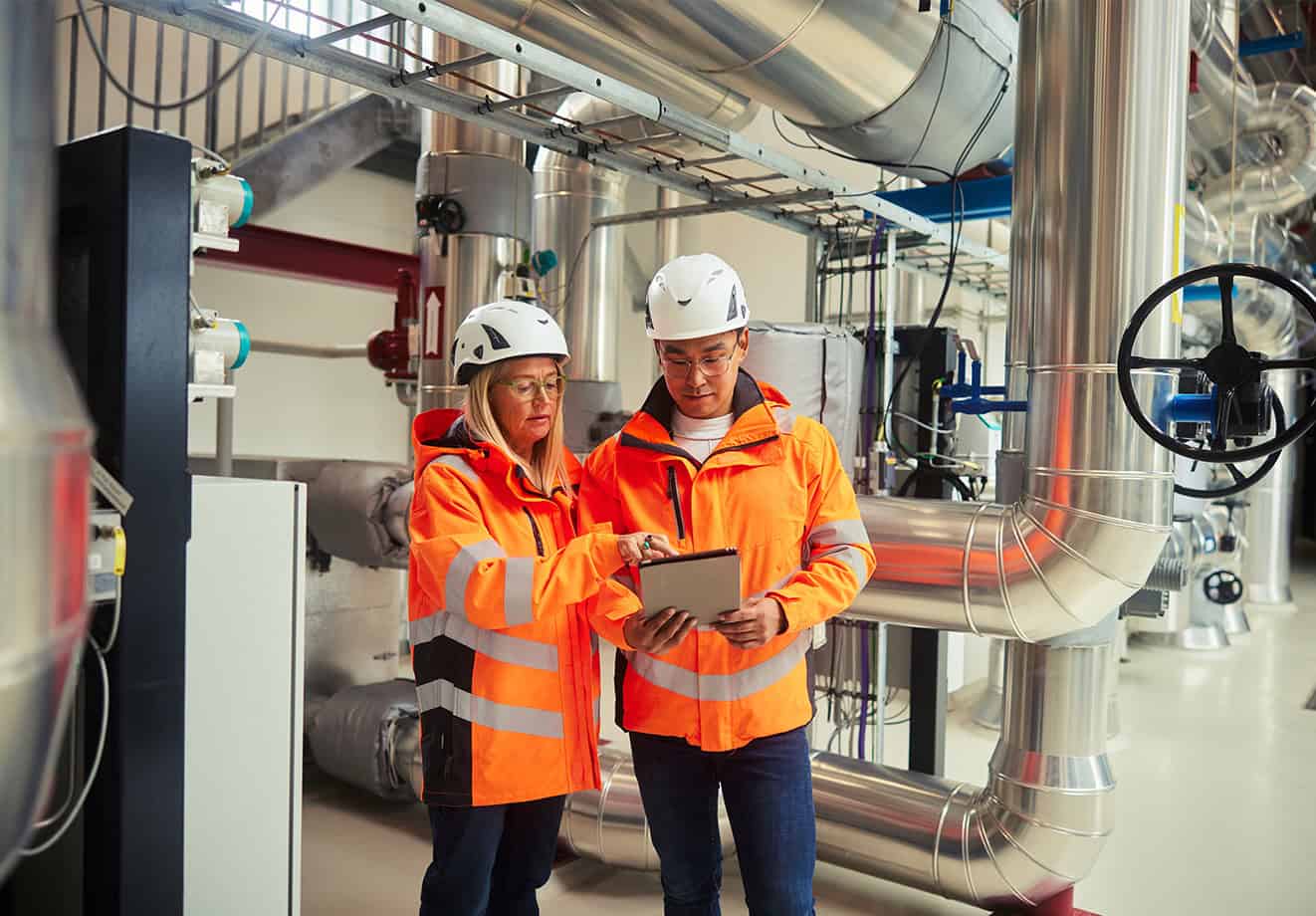Two engineers standing together in a power station