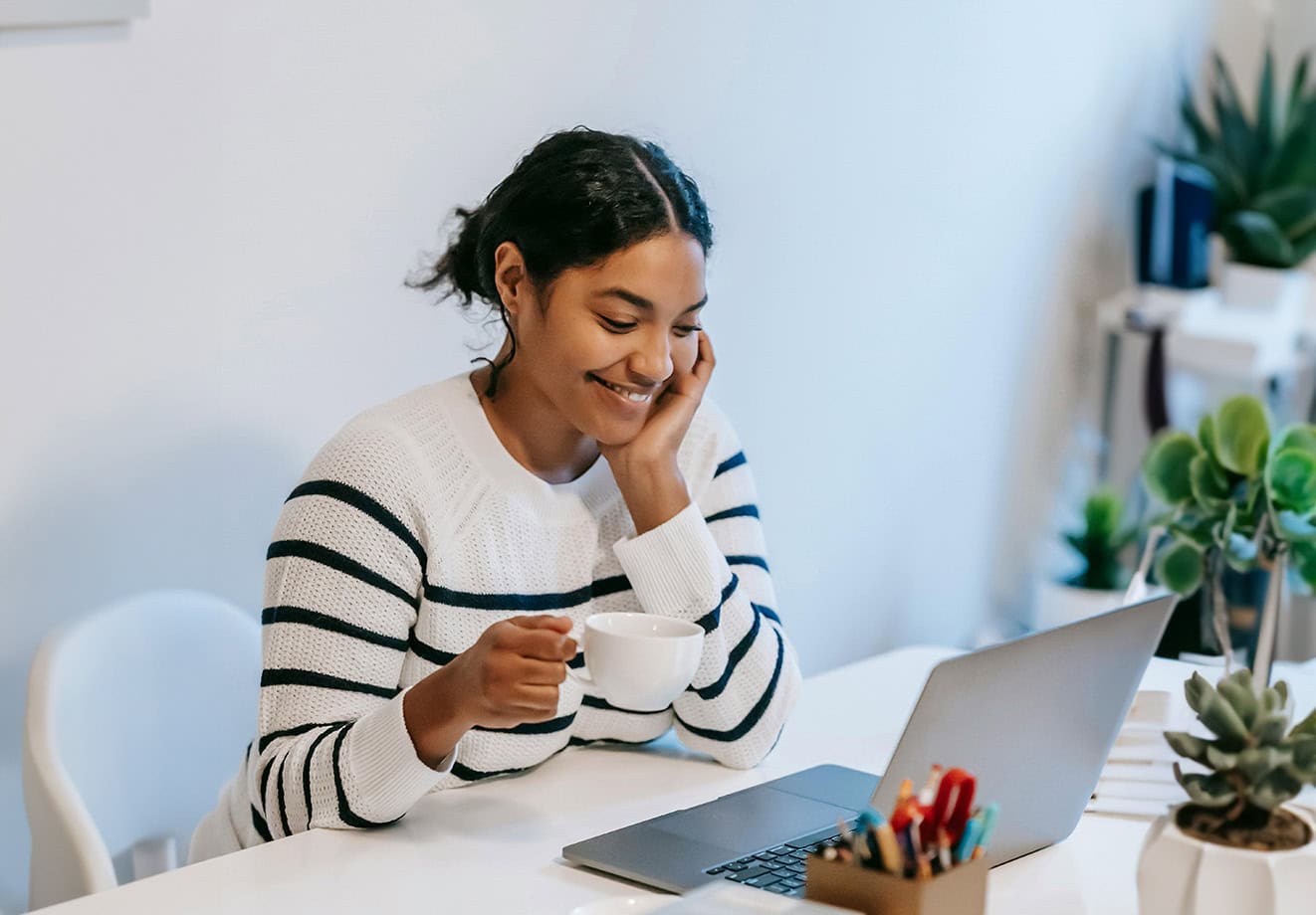 Smiling student working on laptop at desk