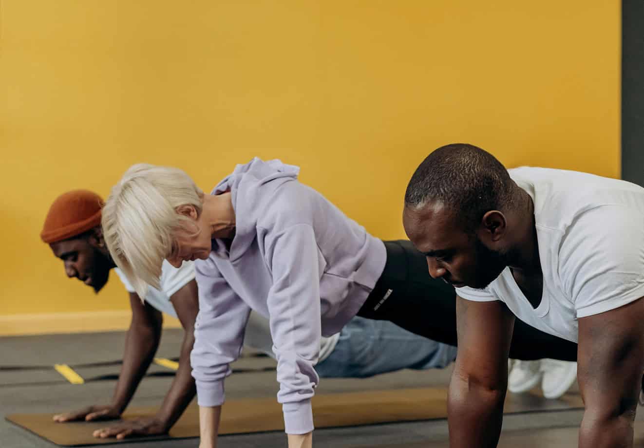 Three people doing pushups