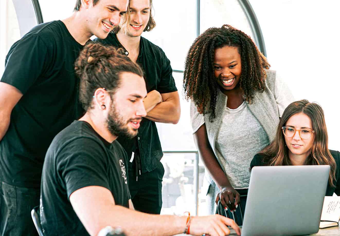 Students working around laptop on desk