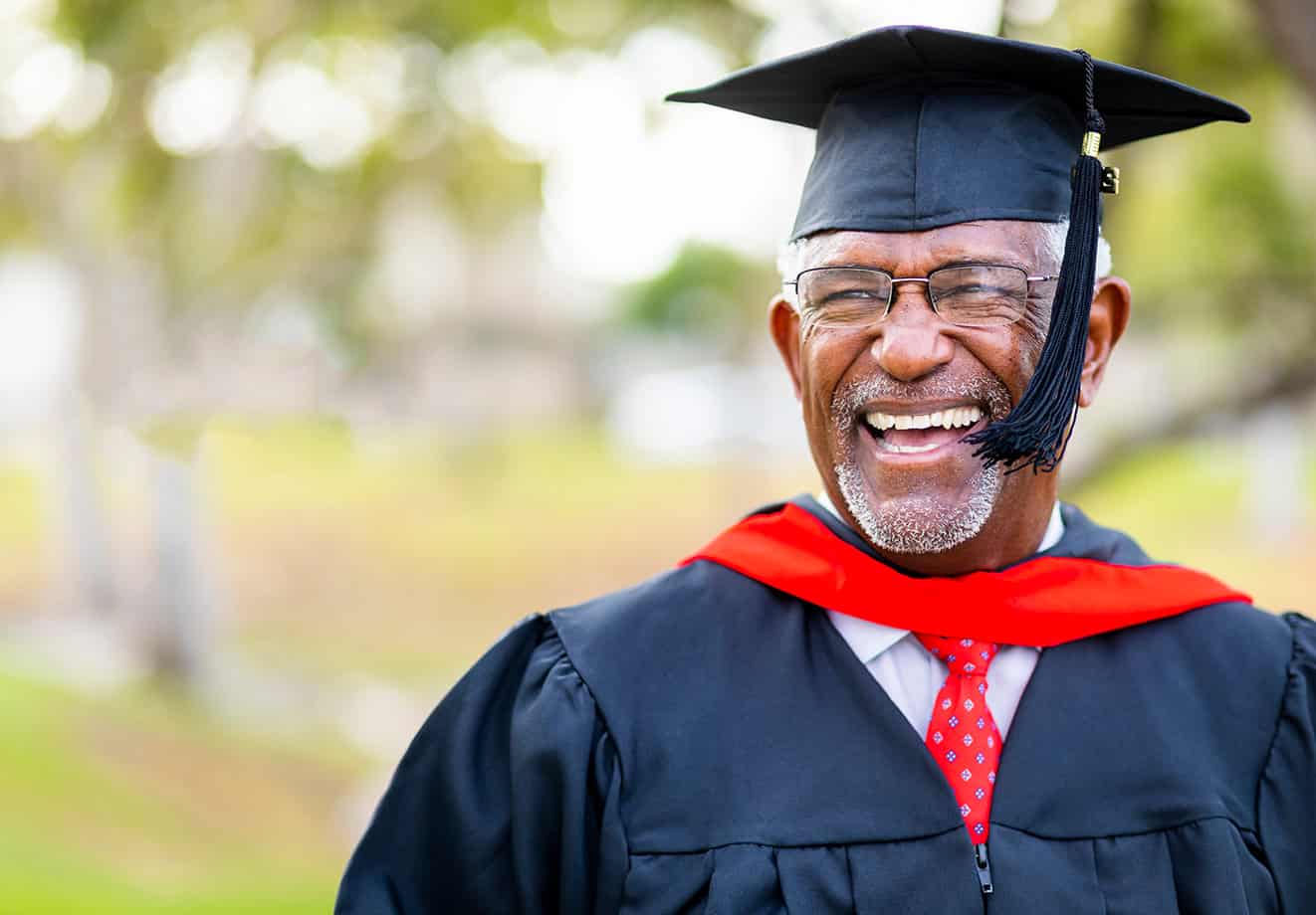 A man in graduation cap and gown outfit