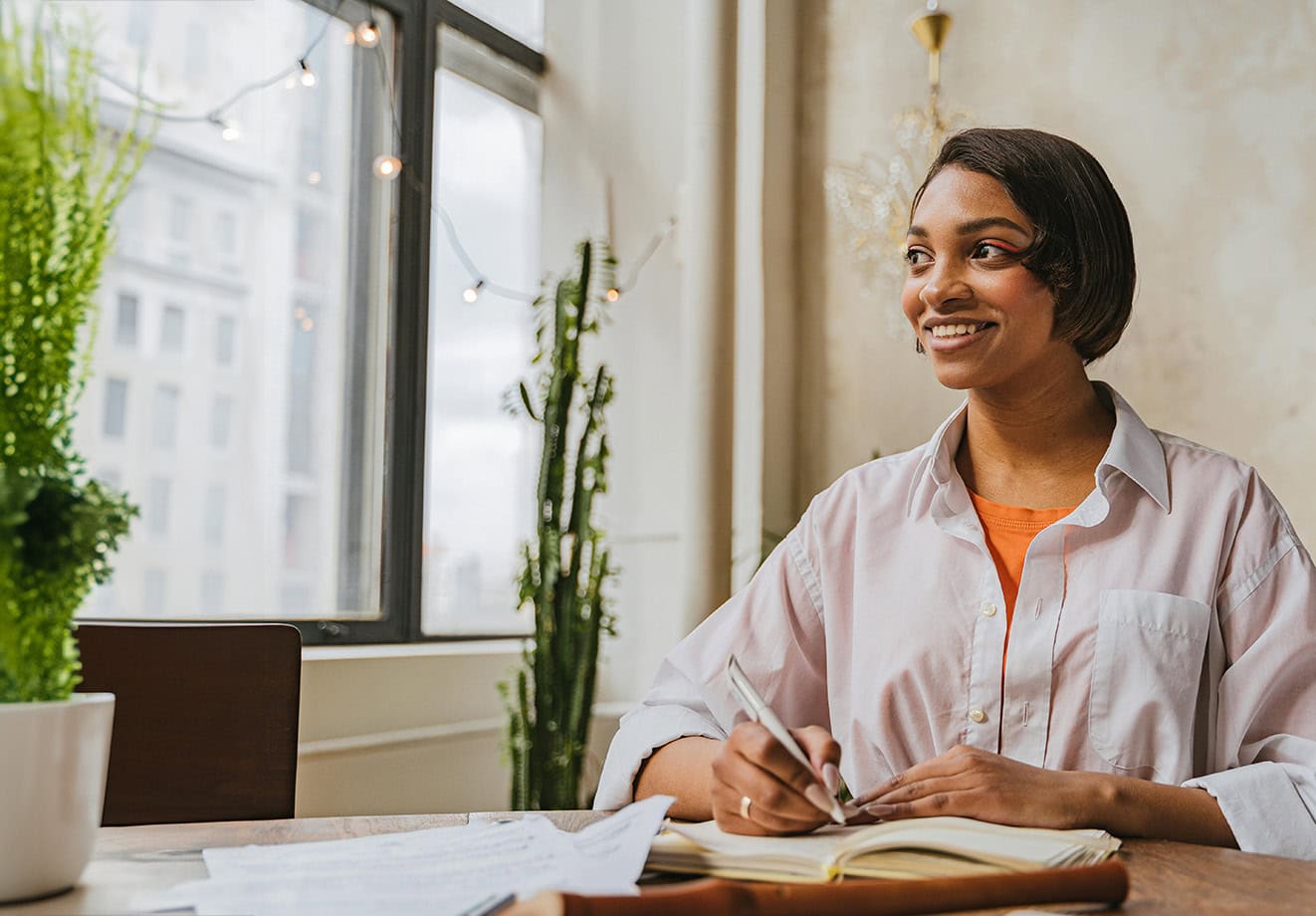 Woman sitting at desk with open notebook
