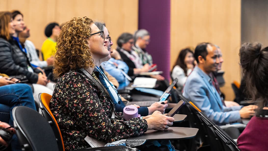 People in a lecture hall watching a presentation