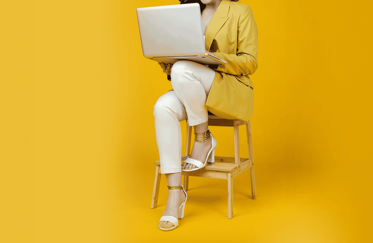 Woman sitting on stool with laptop