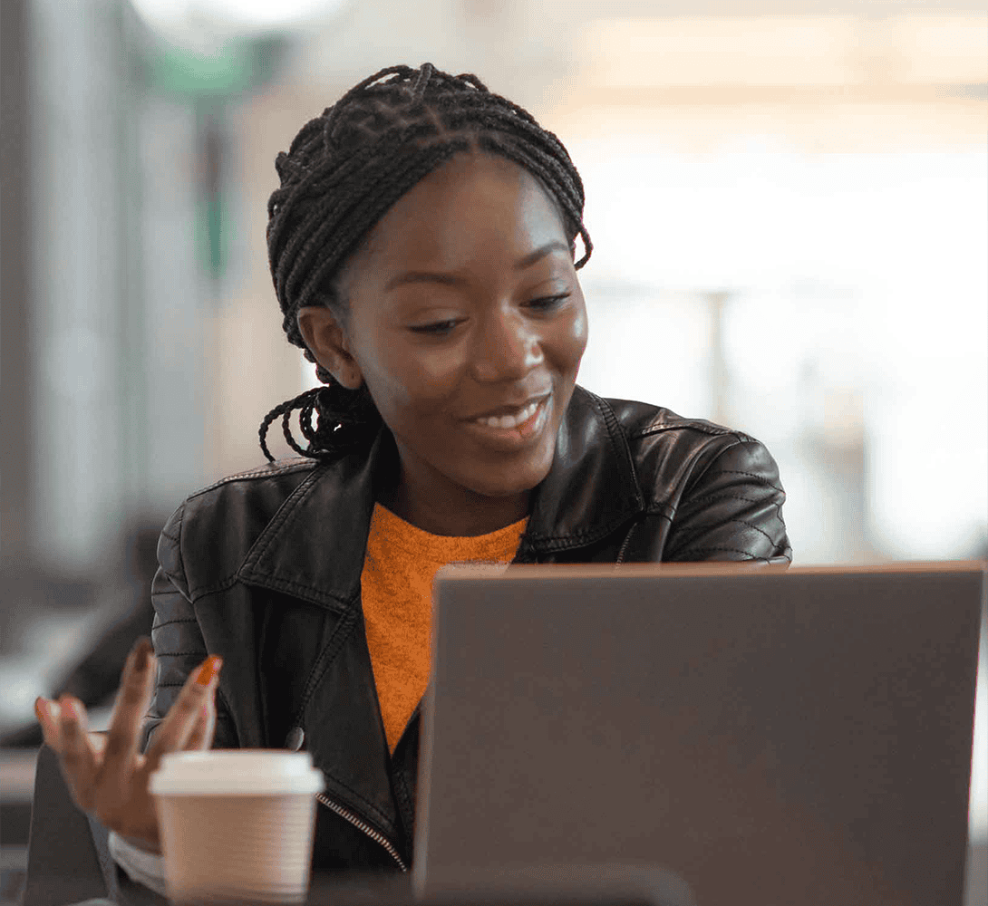 Woman sitting in cafe with open laptop