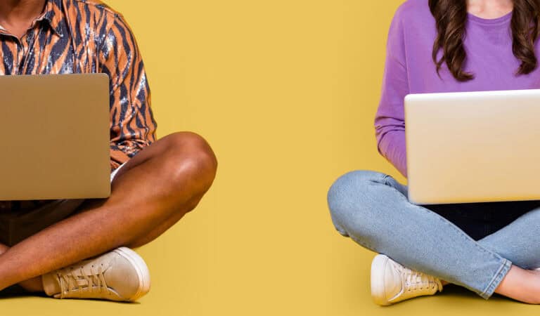 Two students sitting beside each other with laptops