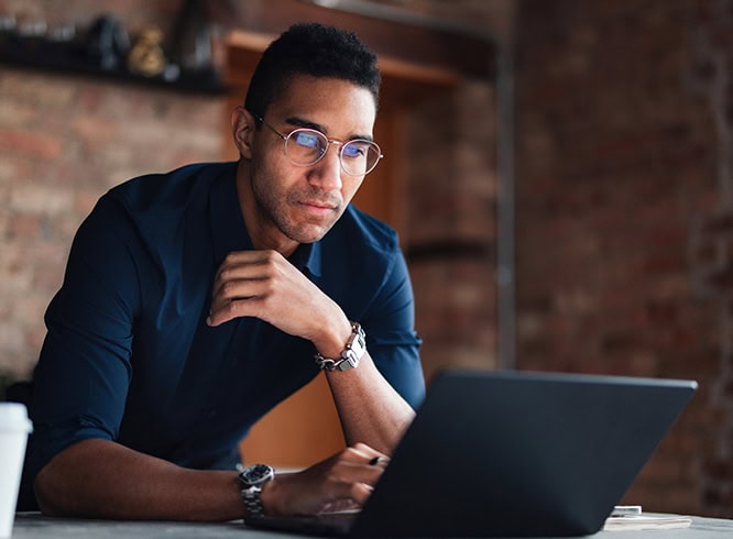 Man working on laptop in large, modern office